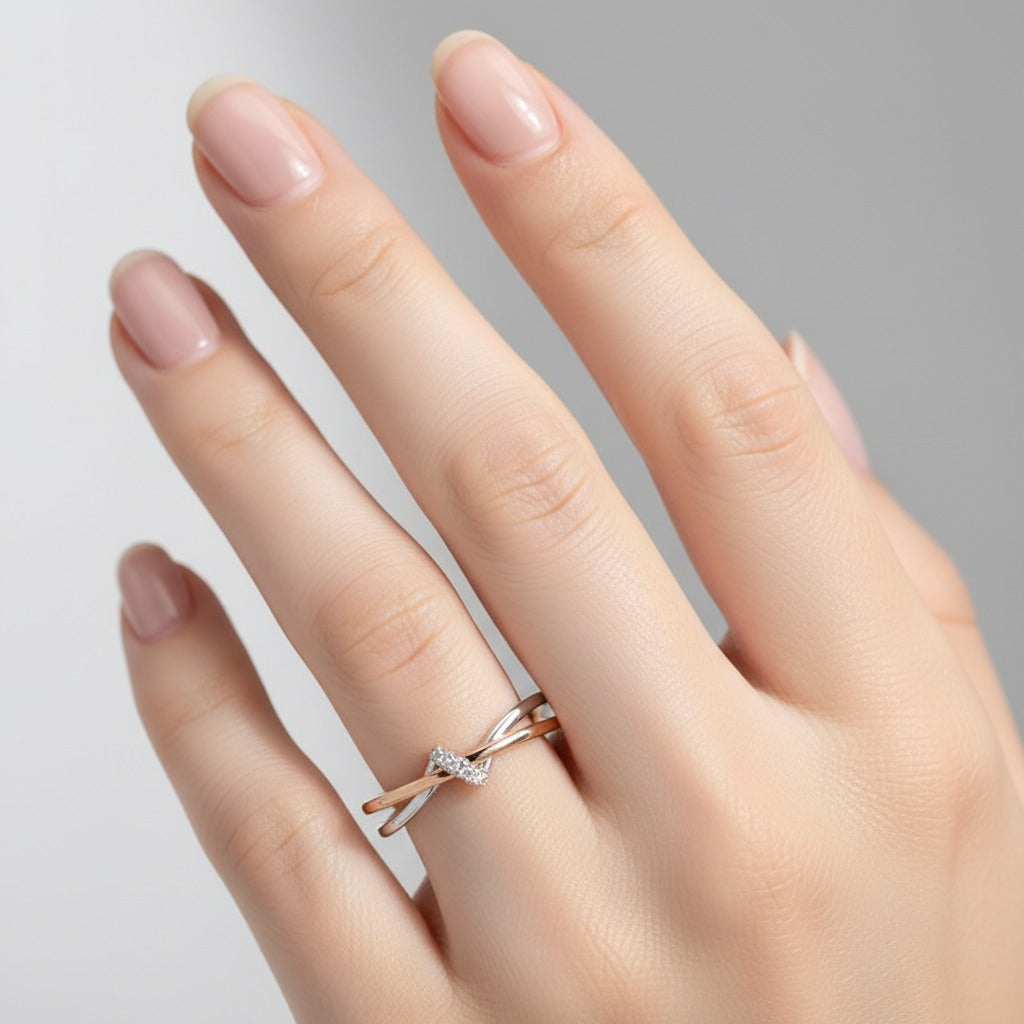 Two interlocking gold rings with a diamond on a light gray background