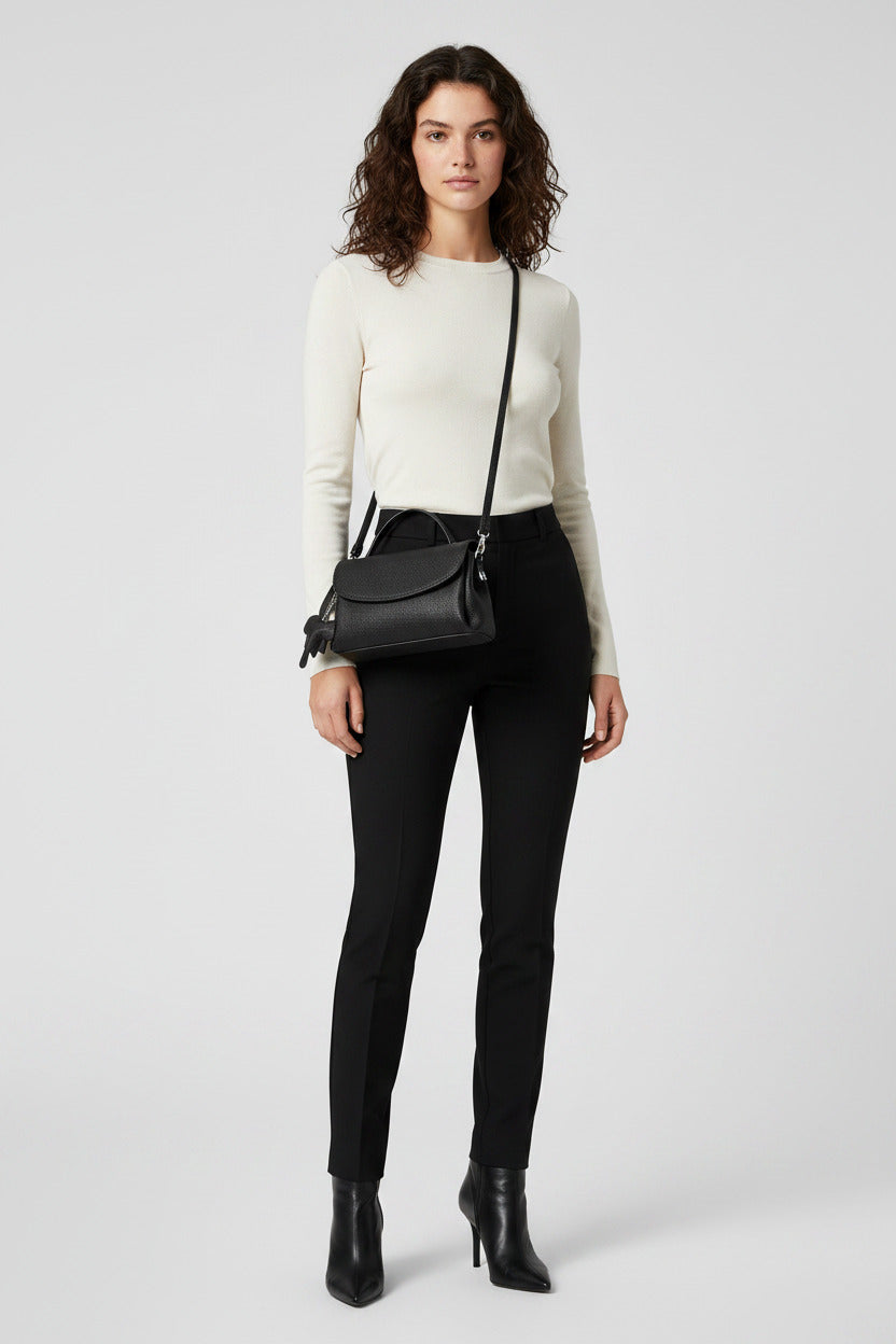 Black handbag with a strap on a white background