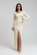 A woman stands outdoors on a sidewalk wearing a fitted, long-sleeve cream maxi dress with a high front slit and a twisted detail at the waist. Two circular inset close-ups on the right show fabric texture details labeled 'DETAILS-1'.
