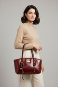 Red handbag with a gold tag on a light gray background