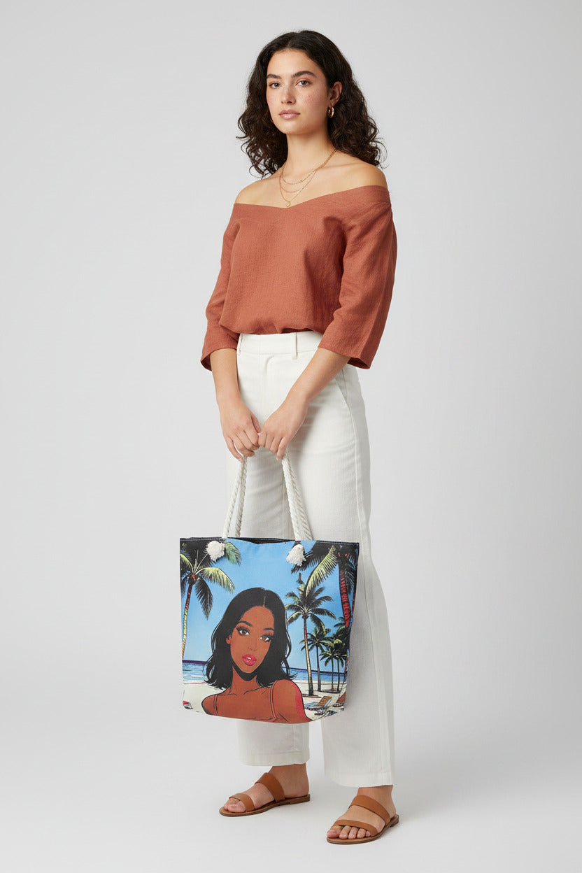 A tote bag featuring a colorful graphic print of a woman on a beach with palm trees, complete with thick white rope handles, shown against a plain white background.