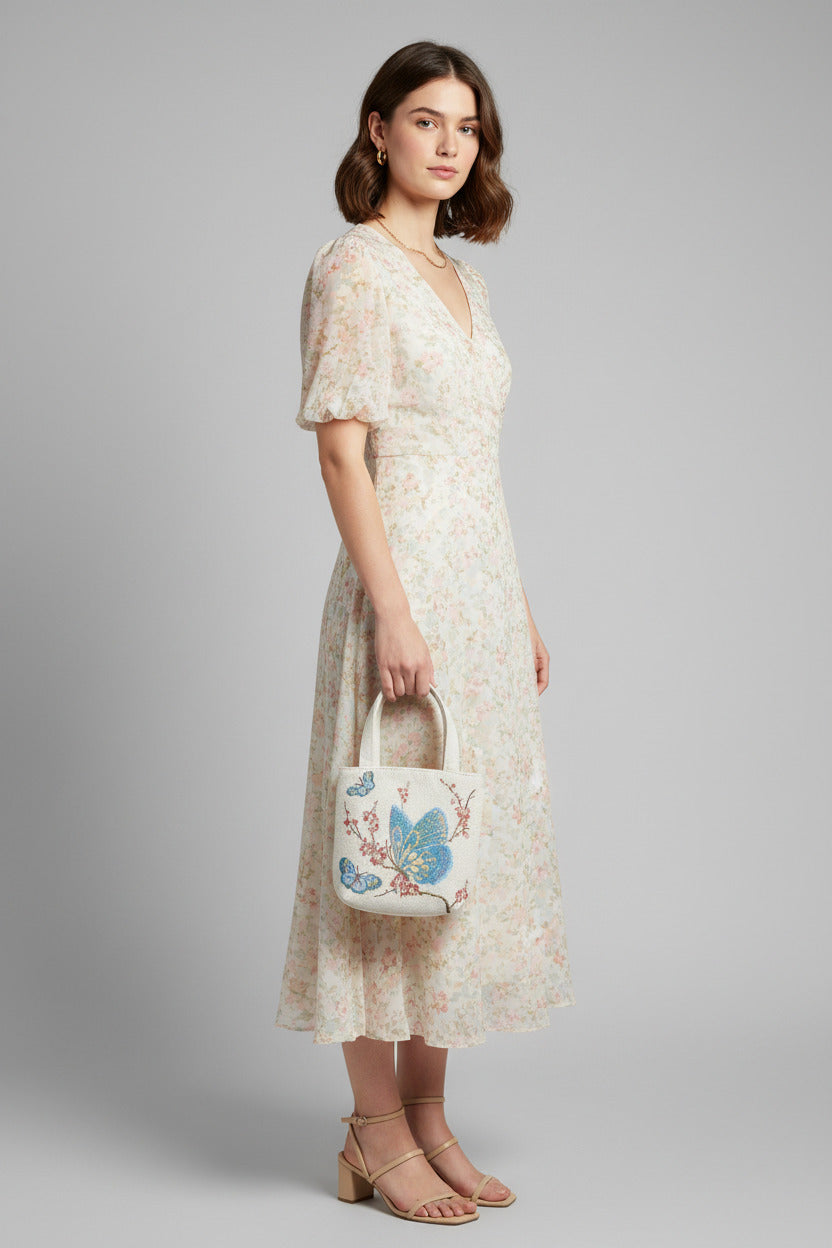 Handbag with butterfly design on a book against a blue background