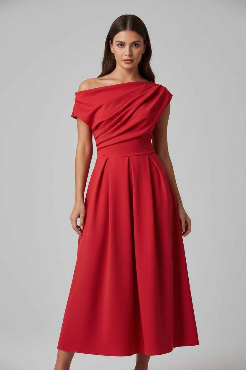 A woman wearing a bright red off-the-shoulder maxi dress with a draped bodice and flared skirt, standing in a living room in front of a large floor mirror.