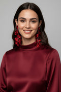 Red floral earrings on a beige background