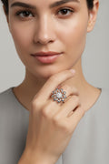 A silver flower-shaped ring with a cluster of clear gemstones in the center, shown on a clean white background with a soft shadow.