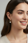 Gold and pearl earrings in a jewelry box with a blurred background