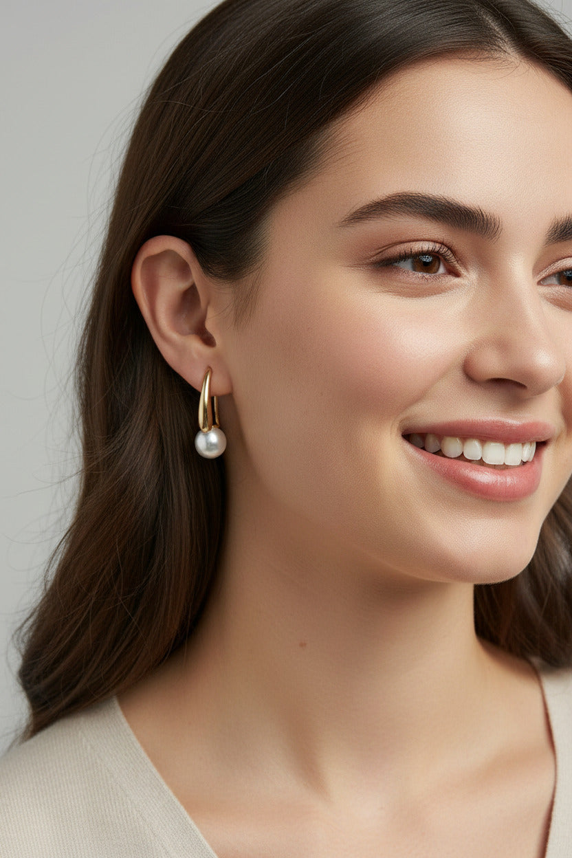 Gold and pearl earrings in a jewelry box with a blurred background