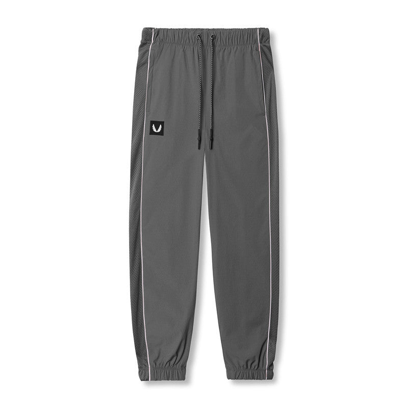 Gray jogger pants with brand logos on a white background