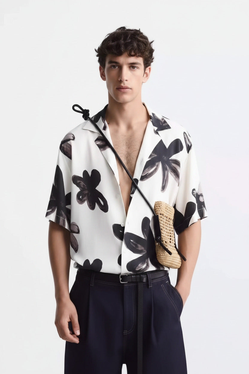 Man wearing a white shirt with black floral patterns, shown from front, back, and side views.