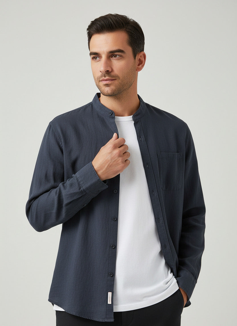 A dark navy blue long-sleeve button-up shirt with a mandarin collar and a chest pocket, styled open over a white t-shirt on a plain white background.