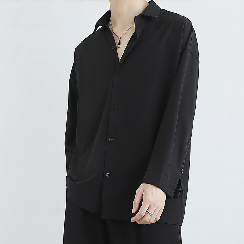 Person wearing a black button-up shirt on a white background