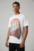 White t-shirt with colorful graphic design on a wooden floor